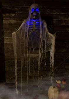 a skeleton sitting on top of a chair in front of pumpkins