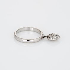 Finely detailed pre owned Tiffany & Co pave diamond heart charm ring crafted in platinum.   Diamonds are pave set into the heart and total an estimated 0.15 carats (estimated at F-G colour and VVS2 clarity).   The stylish ring features a diamond set heart, suspended from the band to allow for movement. The ring is impactful in design and ideal worn day or night. The ring was originally available at Tiffany & Co approx. ten years ago and has since been retired from retail.   The ring is in fair c Classic Heart Ring With Brilliant Cut Diamond, Classic Diamond Heart Ring With Brilliant Cut, Classic Diamond Heart Ring In Diamond White, Pear-shaped Diamond Ring With Pave Setting, Classic Diamond-cut Heart Diamond Ring, Classic Diamond Cut Heart Ring, Classic Diamond Heart Ring With Diamond Cut, Diamond White Heart-shaped Diamond Ring, Diamond Heart Ring With Pave Setting