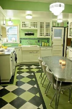 a kitchen with green walls and black and white checkered flooring on the floor