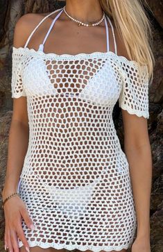 a woman wearing a white crochet swimsuit