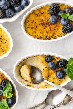 four bowls filled with dessert and topped with blueberries