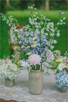 three vases filled with flowers on top of a table