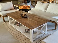 a living room with two white couches and a wooden table in the middle of it