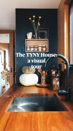 a kitchen with wooden counter tops and black walls, along with stainless steel sink faucets