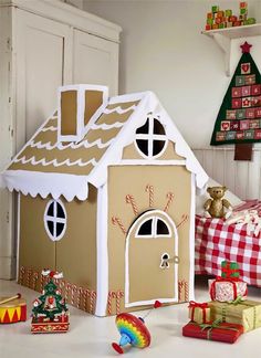 a gingerbread house made out of cardboard and decorated with candy canes on the floor