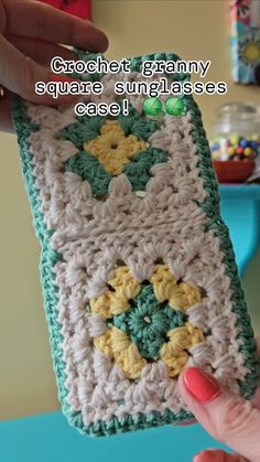 someone is holding up a crochet granny square sun glasses case