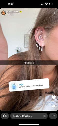 a girl with ear piercings is looking at her phone