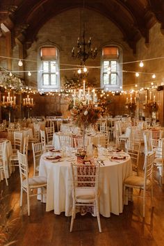 a banquet hall with tables and chairs covered in white tablecloths