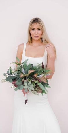 a woman in a white dress holding a bouquet