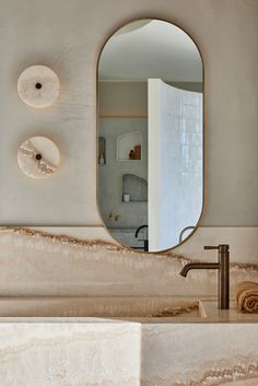 a bathroom sink sitting under a large mirror