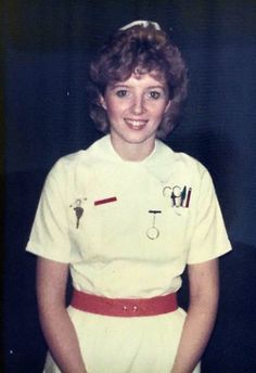 an old photo of a woman in sailor's uniform with scissors on her head