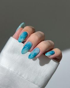 These nails feature a refreshing aqua blue base with delicate white marble veins, reminiscent of tranquil ocean waters. The design is both soothing and striking, perfect for those who love a calming yet stylish look. The glossy finish brings out the depth of the aqua color, making these nails ideal for any autumn outfit.   Photo credit by: @nail.ideas.iran Ocean Nails, Color Block Nails, Water Marble Nails, Baby Blue Nails, Korean Nail Art, Korean Nails, Flower Nail Designs, Blue Nail Designs, Vacation Nails