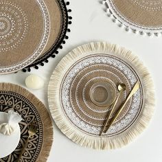 three plates with decorative designs on them and some gold utensils in the middle