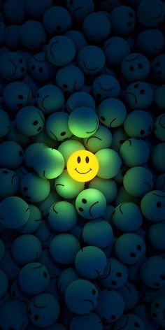 a yellow smiley face surrounded by many green balls with eyes and hands on it's sides