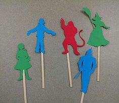 four cupcake toppers in the shape of people and cats on toothpicks