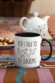 a black and white coffee mug sitting on top of a table next to some cookies