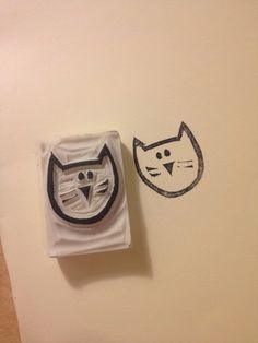 two rubber stamps with cats on them sitting next to each other in front of a white wall