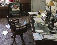 an old fashioned desk is cluttered with papers