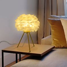 a lamp that is on top of a table next to a couch in a living room