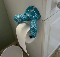 a turtle shaped toilet paper holder is hanging on the wall