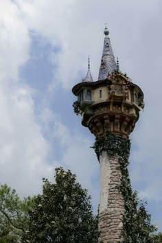 a tall tower with a clock on it's side and ivy growing all over the top