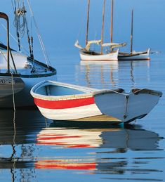 several small boats floating in the water near each other