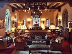 a living room filled with lots of furniture next to tall windows and arched doorways