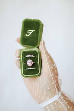 a person holding two rings in their hands with the letter f on them and an eye ring