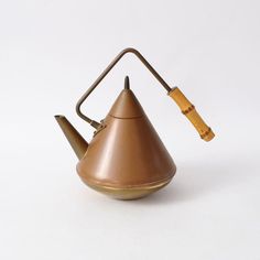 a brown tea pot with a wooden handle