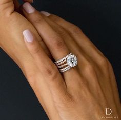 a woman's hand with two rings on her fingers and one ring in the middle