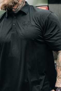 Classy yet nasty. When you need to look professional but still want to wear cool shit. • 100% polyester polo shirt• 2-piece reinforced collar• Back modern yoke• Hemmed sleeves and bottom• Side vents• Modern fit -Embroidered black logo 2.5 x 2 inches -Pictured wearing XL at 5 foot 11 / 215 lbs Black Casual Top For Outdoor Work, Casual Black Top For Outdoor Work, Black Polo Shirt For Workwear, Black Short Sleeve Polo Shirt For Work, Fitted Black Polo Shirt For Streetwear, Black Camo, Top Graphic Tees, Jogger Shorts, Zip Up Hoodies