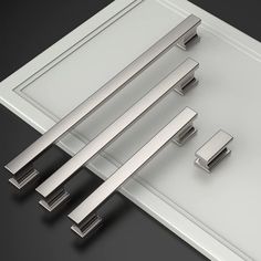 three different types of door handles on a black surface with white trim and silver hardware