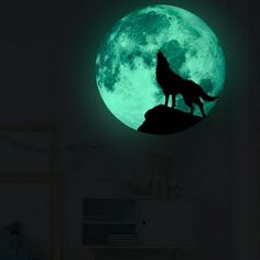 a wolf standing on top of a hill in front of the moon with green glow