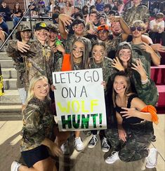 a group of people posing for a photo with a sign that says let's go on a wolf hunt