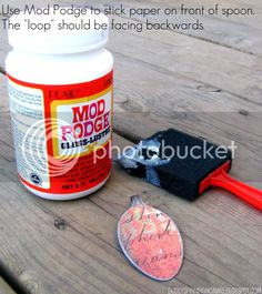 a close up of a bottle of glue next to a patch of paper on a wooden table