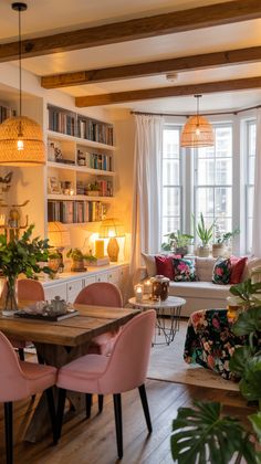 a living room filled with furniture and a wooden table surrounded by potted greenery