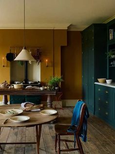 a dining room table with plates and bowls on it in front of a kitchen island