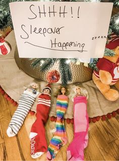 there are five sock dolls laying on the floor next to a sign that says shhh i sleepover happening