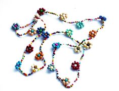 "Add colorful floral fun to your outfits with this charming necklace featuring hand-beaded flowers all along its generous 24\" length! Vibrant multicolored beads form little flowers and add delicate, yet eye-grabbing style as they dangle! And perhaps buy a couple chains at a discount to double the floral loveliness! And consider a coordinating ankle bracelet, pictured above to complete your set! Beaded Flower Necklace (elasticized cord), 24\" long, flowers 1/2\" diameter MANY ARTFUL ITEMS ARE AV Beaded Flower Necklace For Summer Gifts, Bohemian Multicolor Flower Necklace For Summer, Summer Flower Beaded Necklaces, Multicolor Round Beads Flower Necklace For Summer, Summer Floral Beaded Chain Necklace, Summer Flower Shaped Beaded Necklace With Tiny Beads, Summer Flower Necklace With Tiny Beads, Summer Flower-shaped Beaded Necklace With Tiny Beads, Summer Flower Necklace With Tiny Round Beads