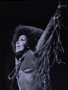 a woman with an afro is performing on stage