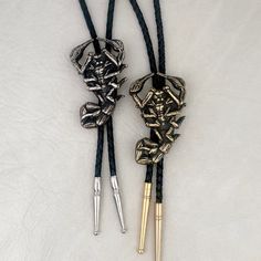 "Original scorpion design was hand carved, then cast in the Heliotrope studio in Tucson, AZ. Cast in solid brass (gold tone), or white bronze (silver tone). Cord is machine braided black or tan leather. At checkout, please choose the desired cord length: 36\"----- Recommended for people under 6' tall. 42\"----- Recommended for people 6' tall or taller. Scorpion measures 2.4\" tall x 1.5\" wide. PLEASE NOTE: final two photos (AND the video) show a comparison between the LARGE SCORPION BOLO TIE (t Black Concho Jewelry For Rodeo, Black Engraved Western Jewelry, Black Concho Jewelry For Western-themed Events, Black Southwestern Jewelry For Rodeo, Southwestern Black Jewelry For Rodeo, Western Black Jewelry For Rodeo, Black Western Style Jewelry For Rodeo, Vintage Black Jewelry For Western-themed Events, Western Engraved Jewelry For Rodeo