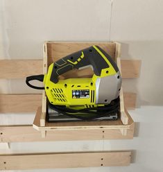 a yellow and black power tool in a wooden box