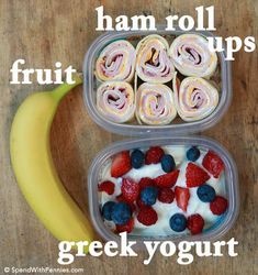 two plastic containers filled with fruit and rolls next to a banana on a wooden table