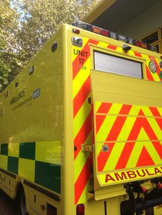 an ambulance parked in front of a building with trees behind it and the words umbila written on the side