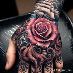 a hand with an octopus, rose and ship tattoo on it's left palm