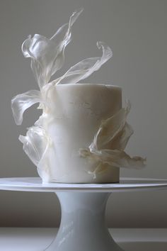 a white cake with frosting on top sitting on a plate