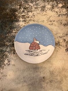 a plate with a cartoon bear on it sitting on a counter top in the snow