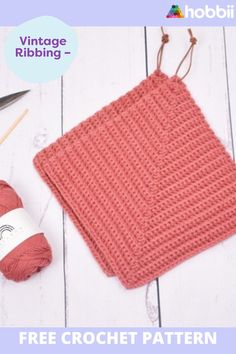 a crochet square with yarn and knitting needles next to it