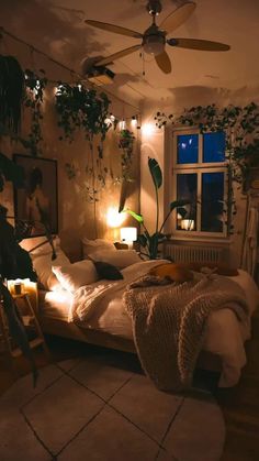 a bed room with a neatly made bed next to a window and potted plants