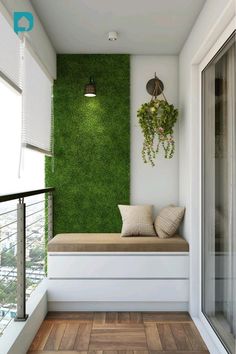 a window seat sitting on top of a wooden floor next to a green plant wall